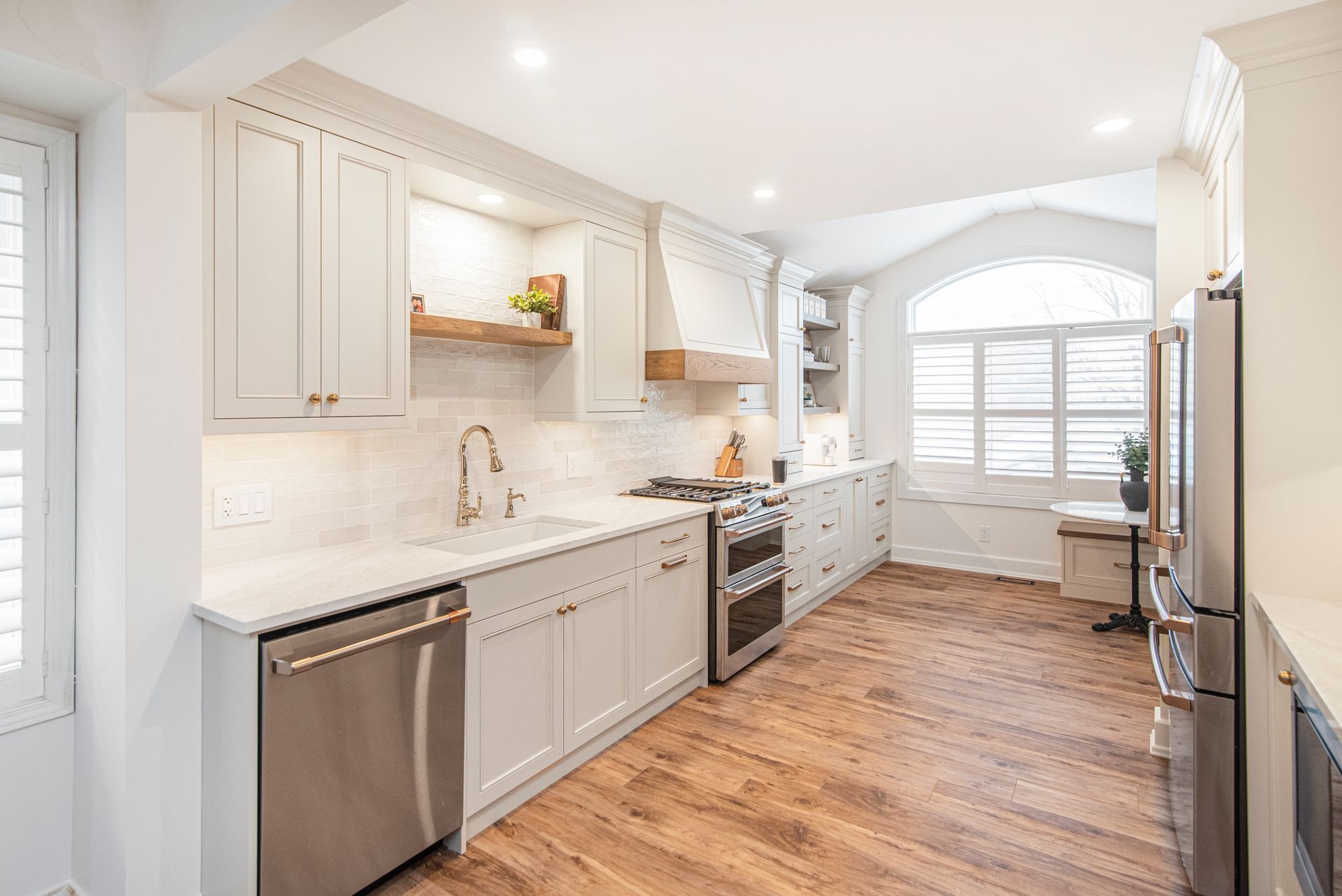 A kitchen with white cabinets , stainless steel appliances , and hardwood floors.