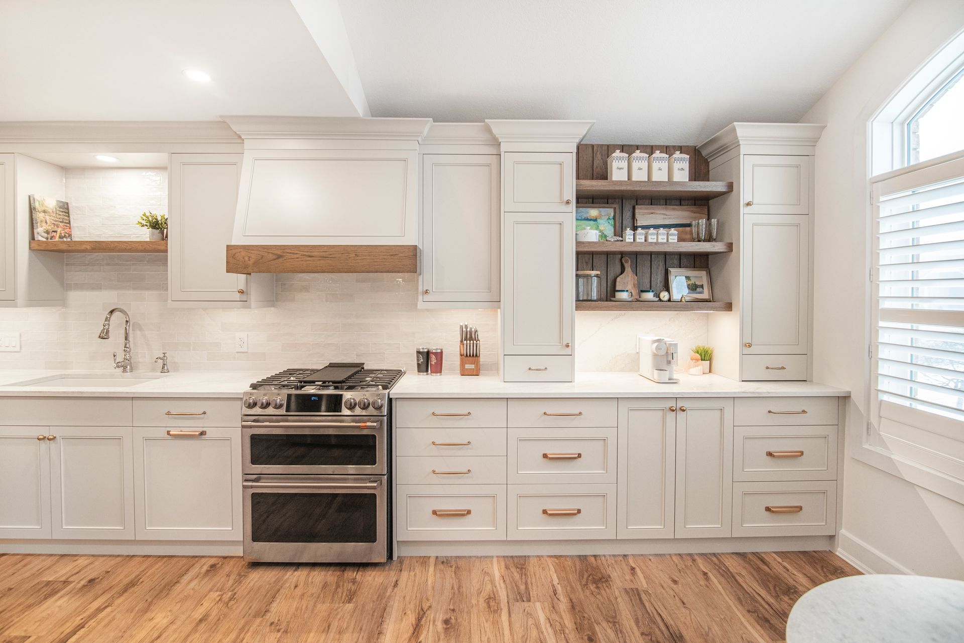 A kitchen with white cabinets , stainless steel appliances , and hardwood floors.
