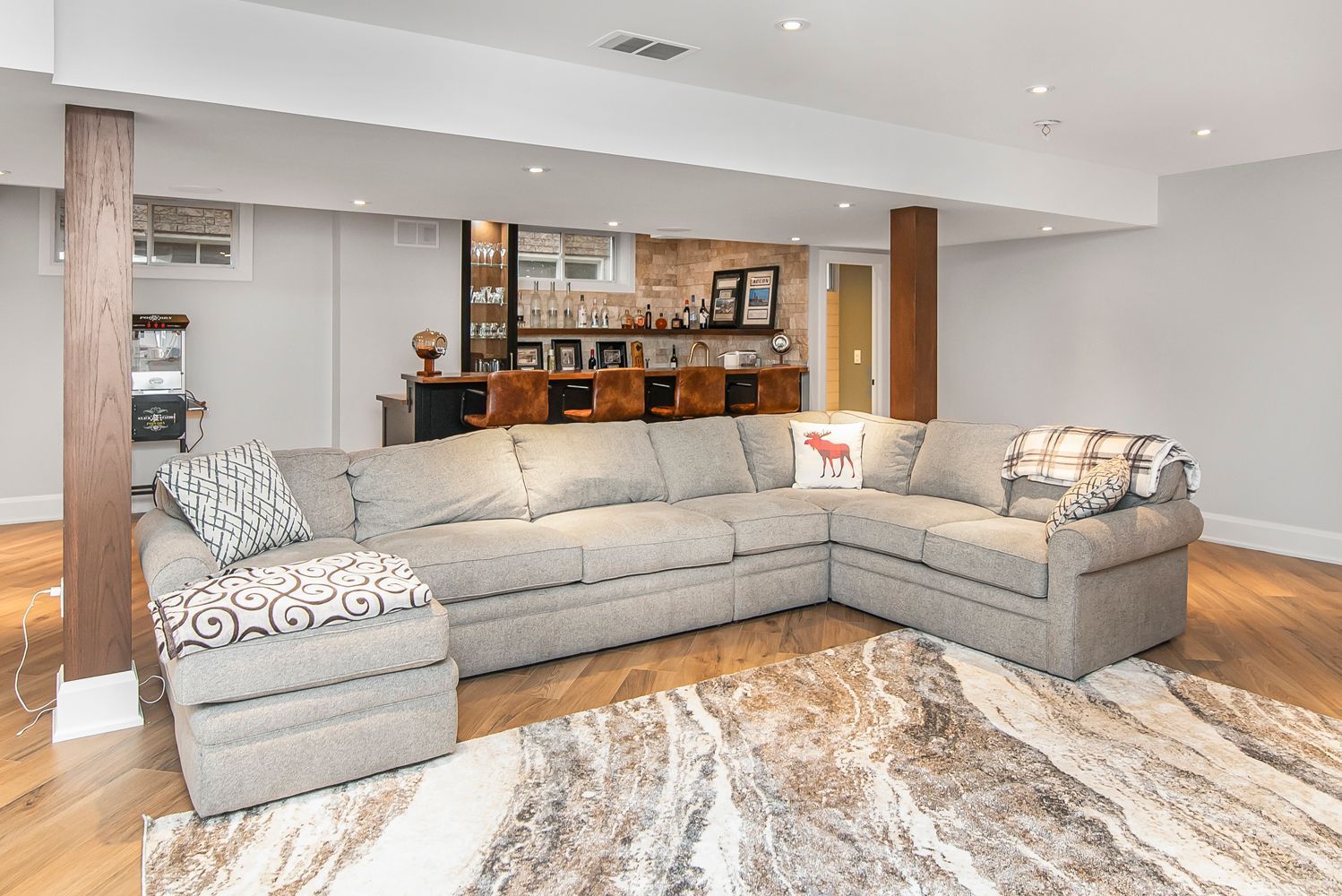 A living room with a large sectional couch and a rug.