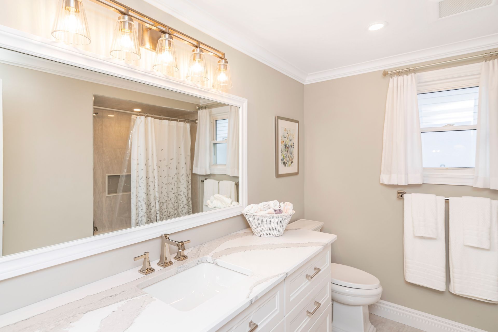 A clean bathroom with a sink , toilet , and mirror.