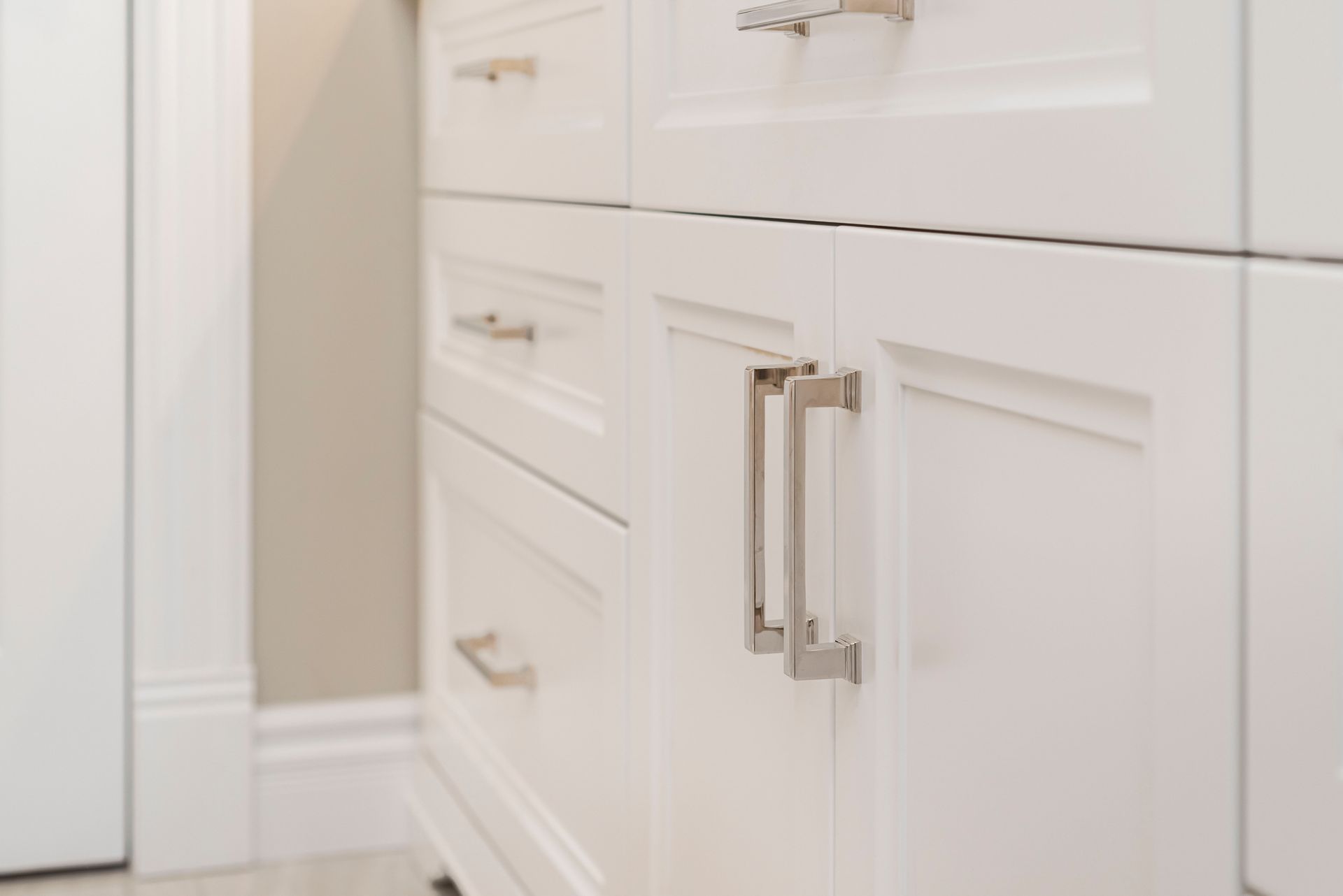 A close up of a bathroom vanity with white cabinets and drawers.