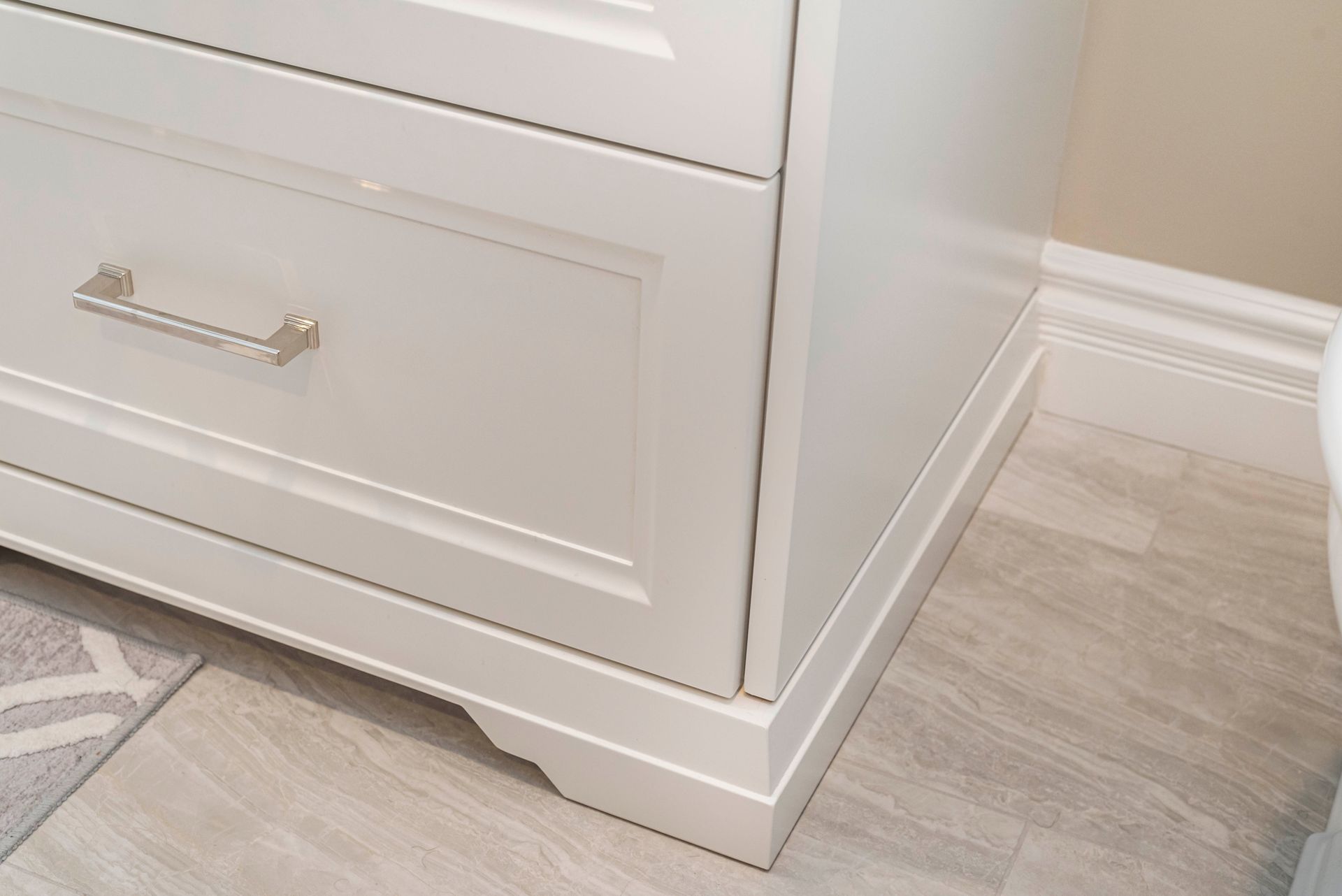 A white dresser is sitting in a bathroom next to a toilet.