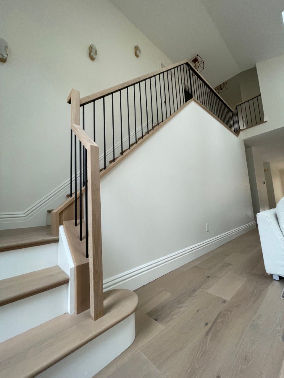 A wooden staircase with a metal railing in a living room