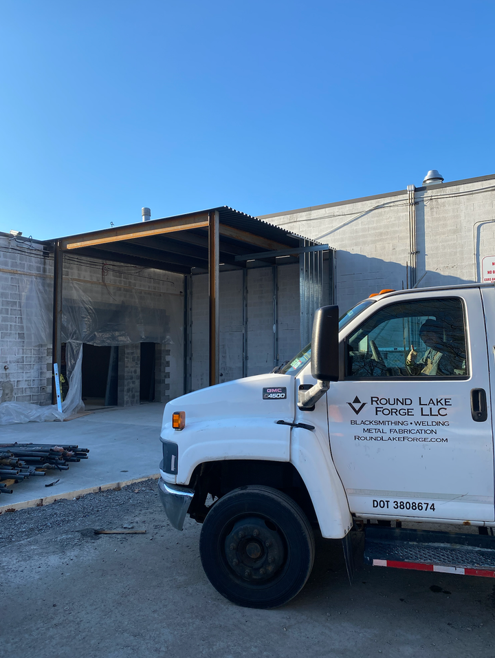 A white truck is parked in front of a building.