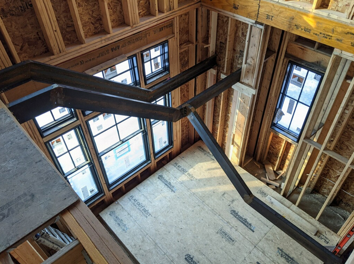 An aerial view of a house under construction with a lot of windows.