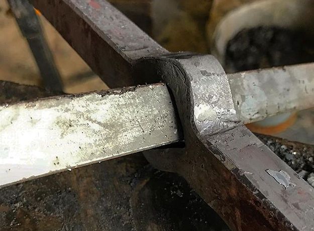 A close up of a piece of metal sitting on top of an anvil.