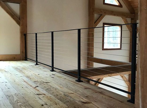 A room with a wooden floor and a metal railing.