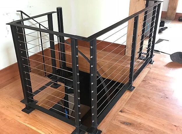 A staircase with a black railing and a wooden floor.