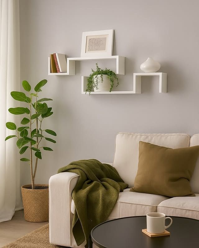 Sala de estar con sofá blanco, estanterías con plantas y libros y acentos verdes.
