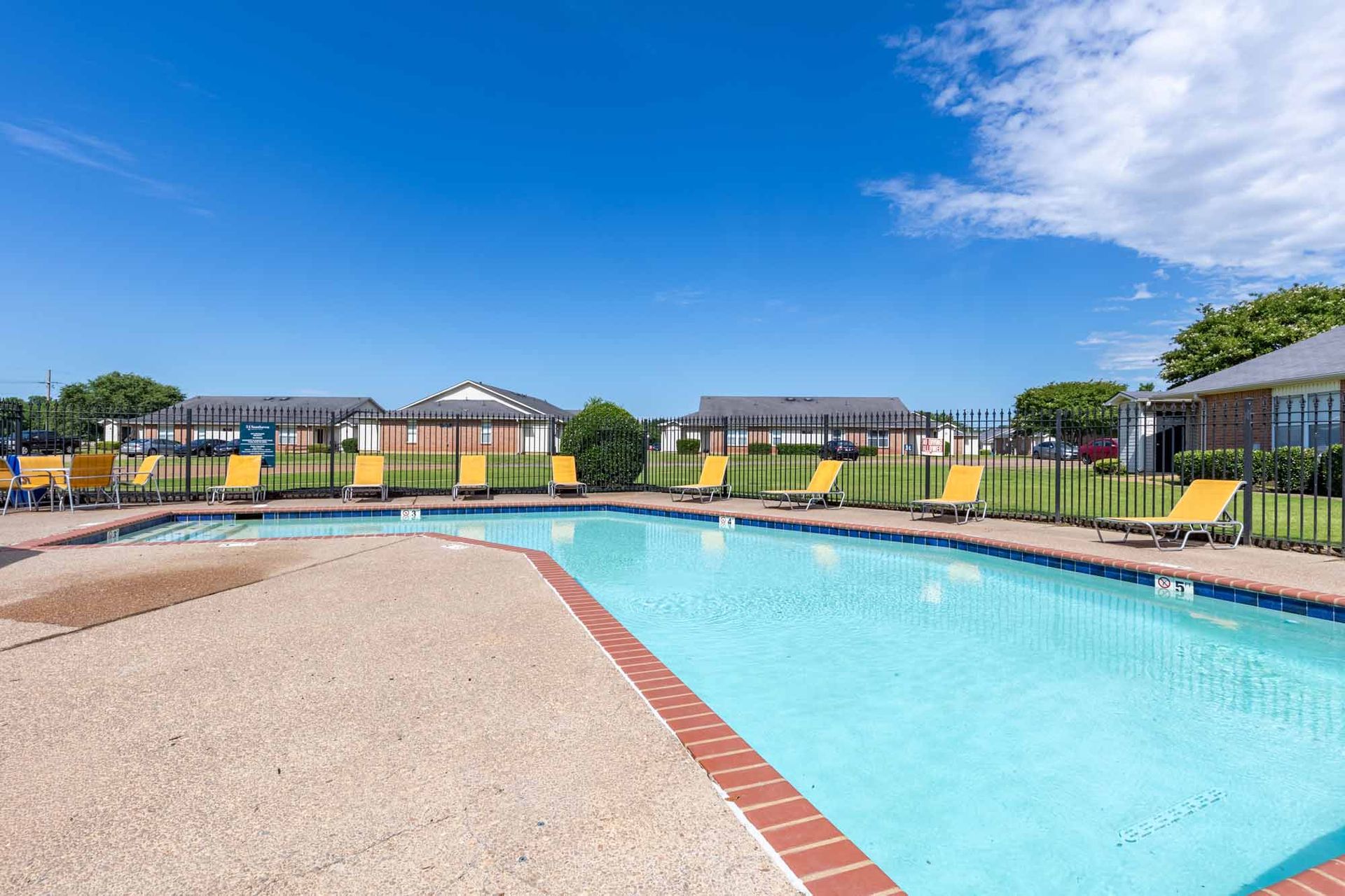 A large swimming pool surrounded by chairs and umbrellas at 51 at Southaven Apartment Homes in Southaven, MS.