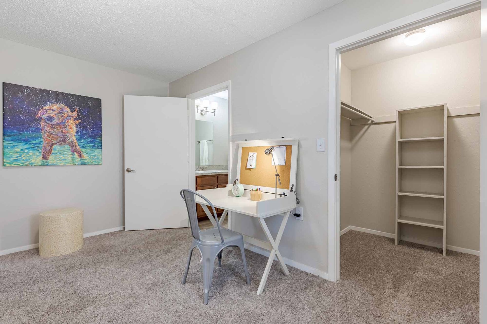 A bedroom with a bed, desk, lamp, and window at 51 at Southaven Apartment Homes in Southaven, MS.