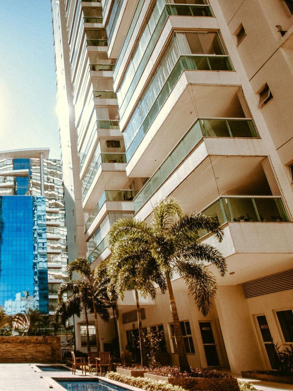 A tall building with a pool in front of it