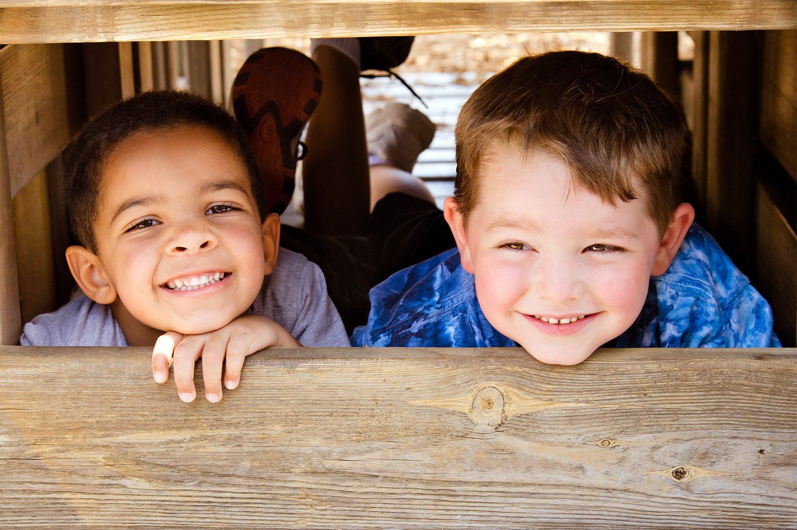 African-American child and caucasian child playing together on playground