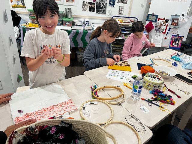 A group of children are sitting at a table making crafts.