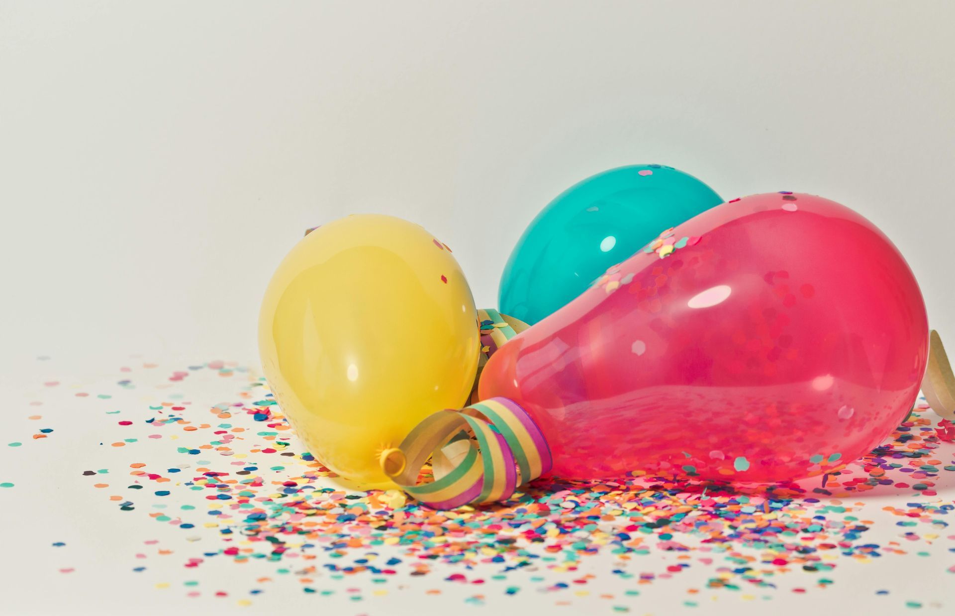 A bunch of balloons and confetti on a table.