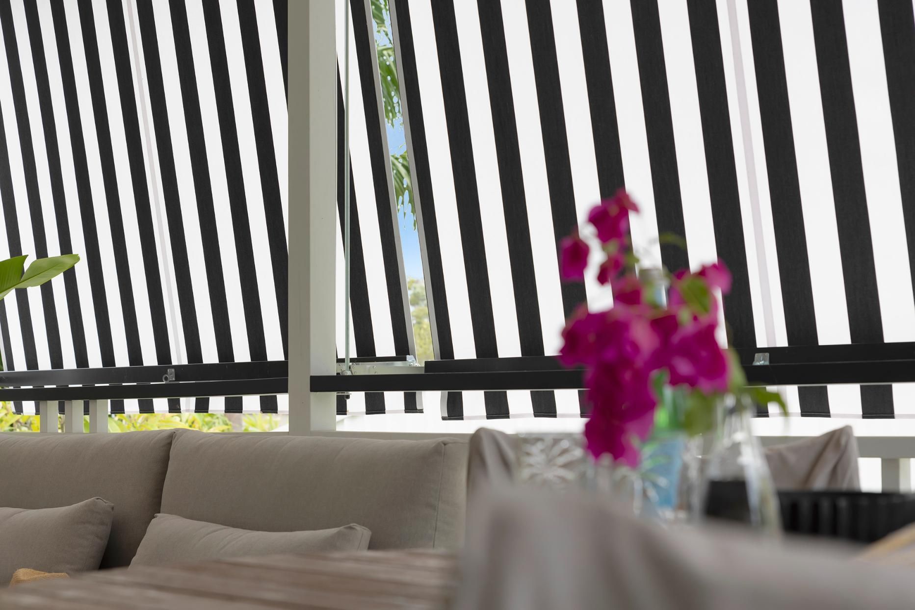A Living Room With A Striped Awning And A Couch  — Wares Blinds, Screens & Awnings In Gladstone Central, QLD