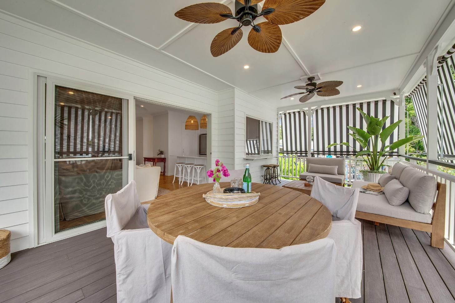 A Porch With A Table And Chairs And A Ceiling Fan  — Wares Blinds, Screens & Awnings In Gladstone Central, QLD
