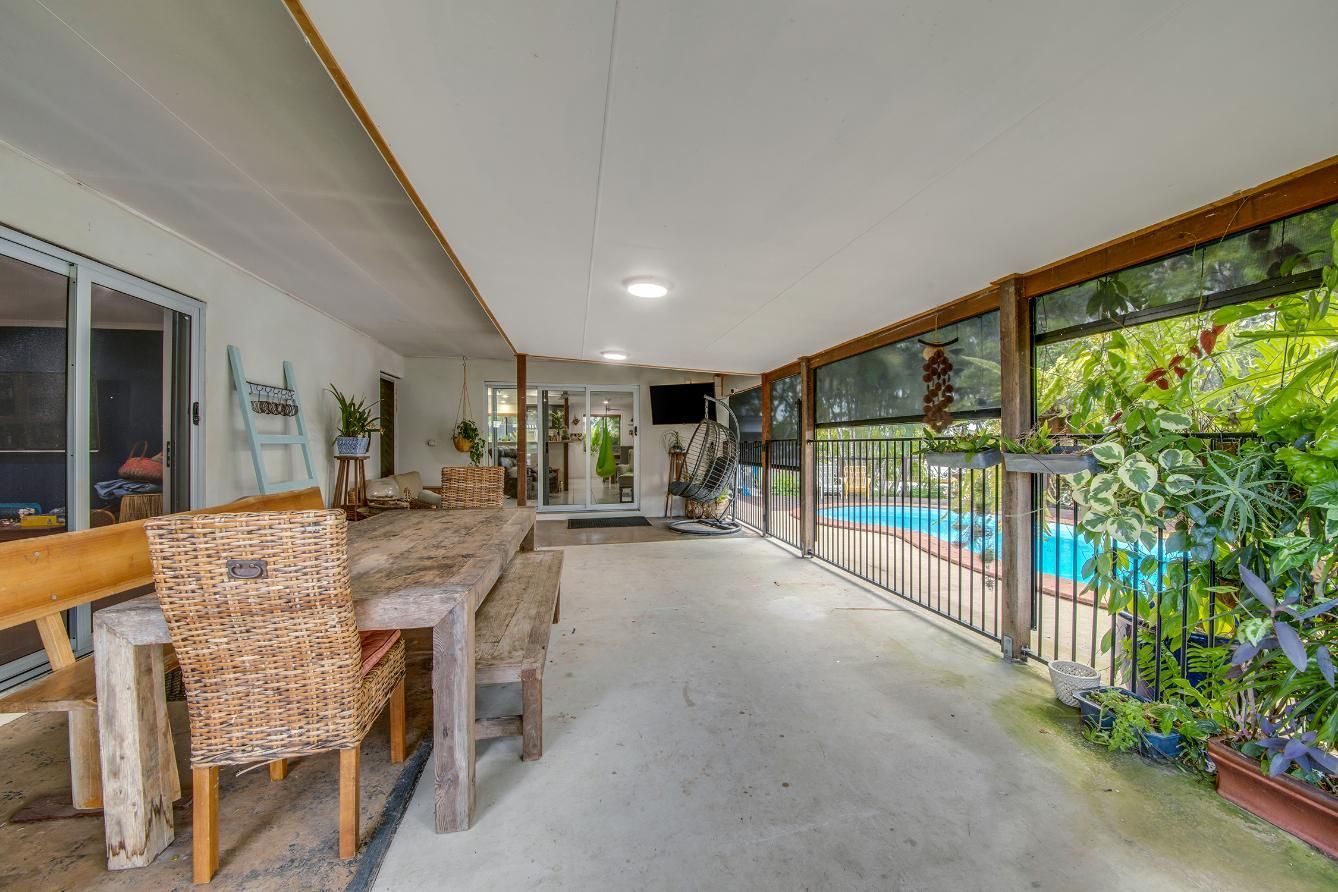 A Table And Chairs And A Swimming Pool In The Background  — Wares Blinds, Screens & Awnings In Gladstone Central, QLD