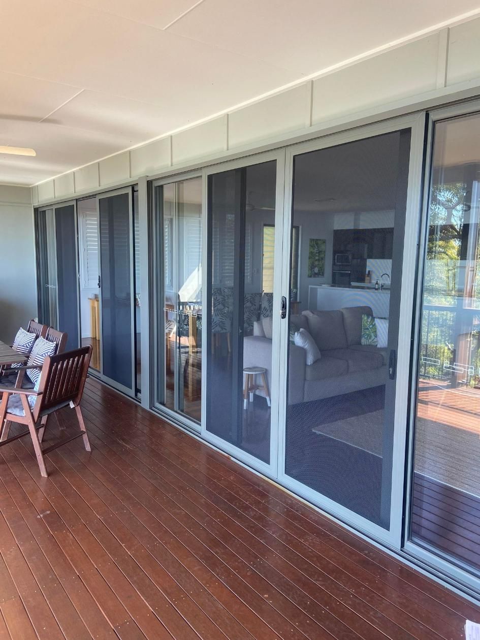 A Living Room With A Couch  And Sliding Glass Doors — Wares Blinds, Screens & Awnings In Gladstone Central, QLD