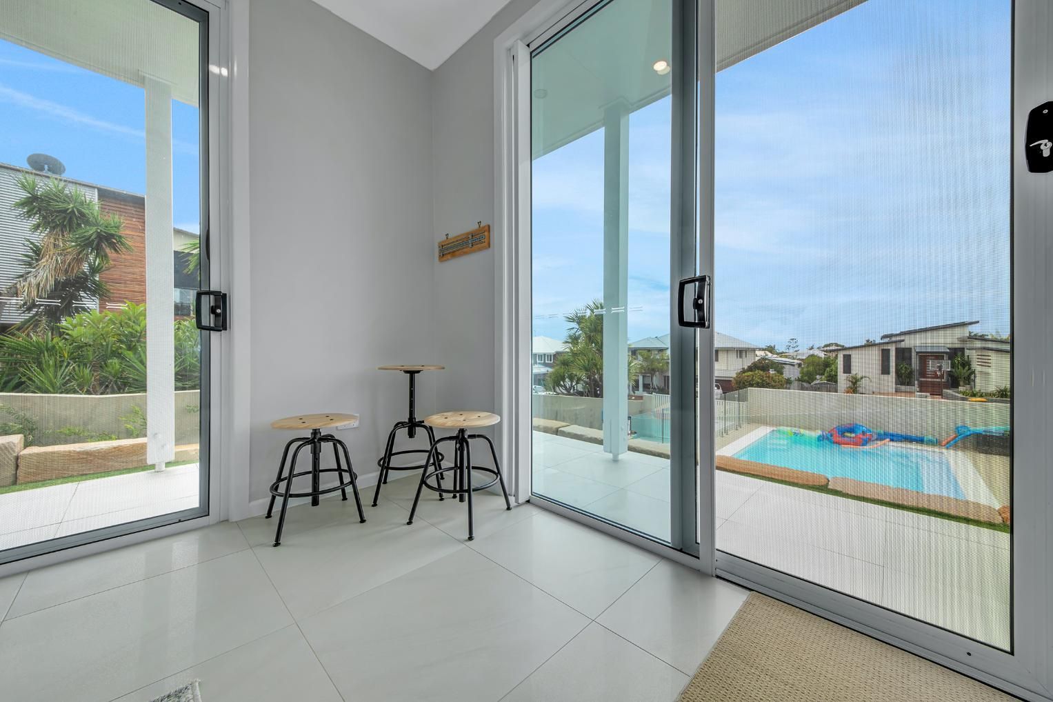 A Room With Stools And A Mesh Door — Wares Blinds, Screens & Awnings In Gladstone Central, QLD
