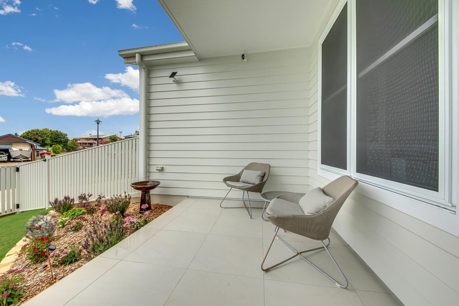 A White House With A Patio With Chairs And A Bird Bath — Wares Blinds, Screens & Awnings In Gladstone Central, QLD