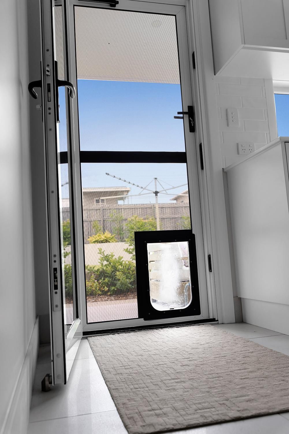 A Door that Has a Pet Door — Wares Blinds, Screens & Awnings In Gladstone Central, QLD