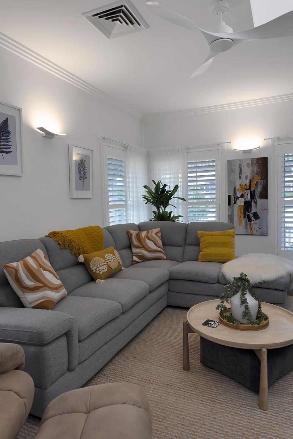 A Living Room With A Large Sectional Couch And A Coffee Table — Wares Blinds, Screens & Awnings In Gladstone Central, QLD