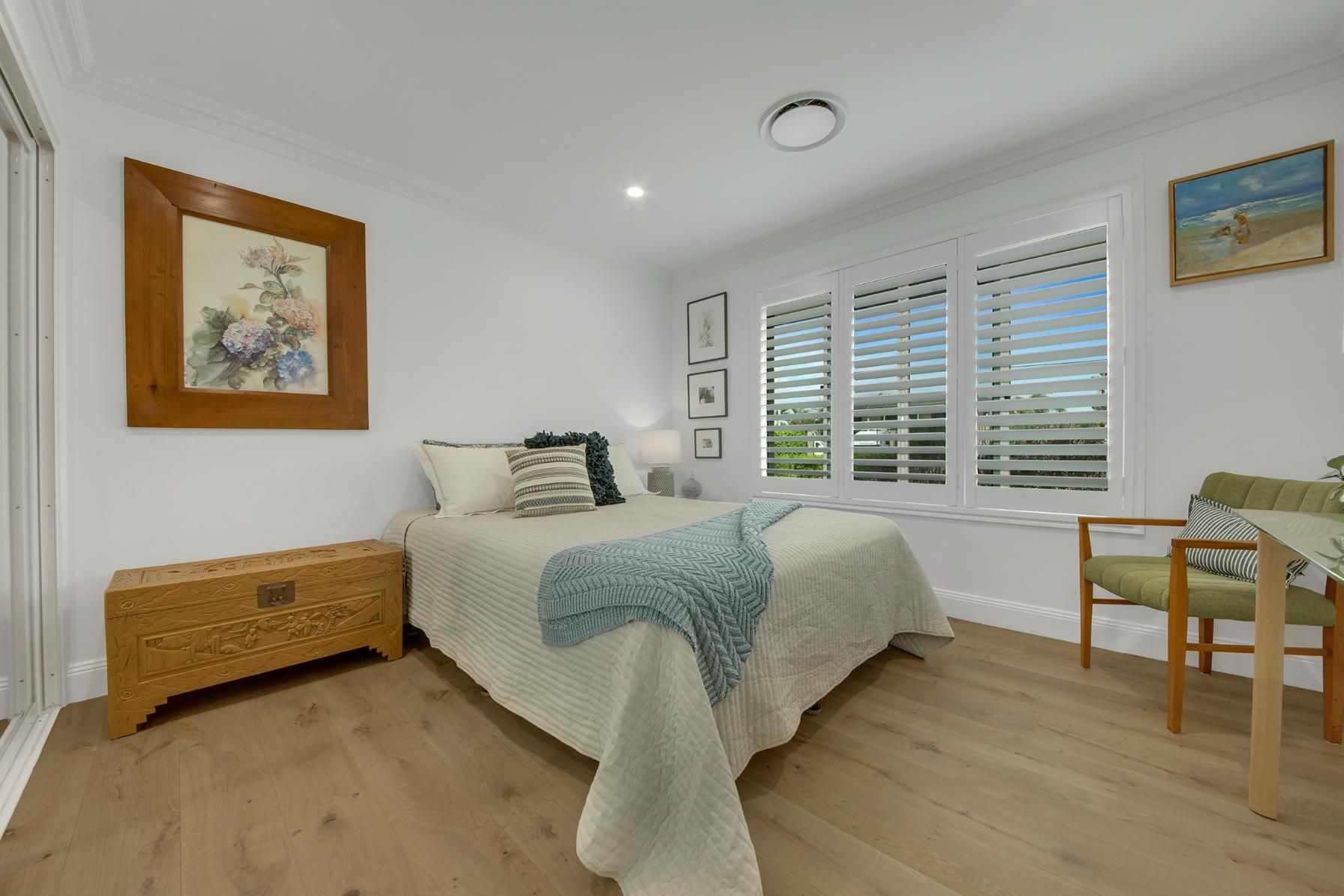 A Bedroom With A Bed , Chair , Nightstand And Shutters  — Wares Blinds, Screens & Awnings In Gladstone Central, QLD