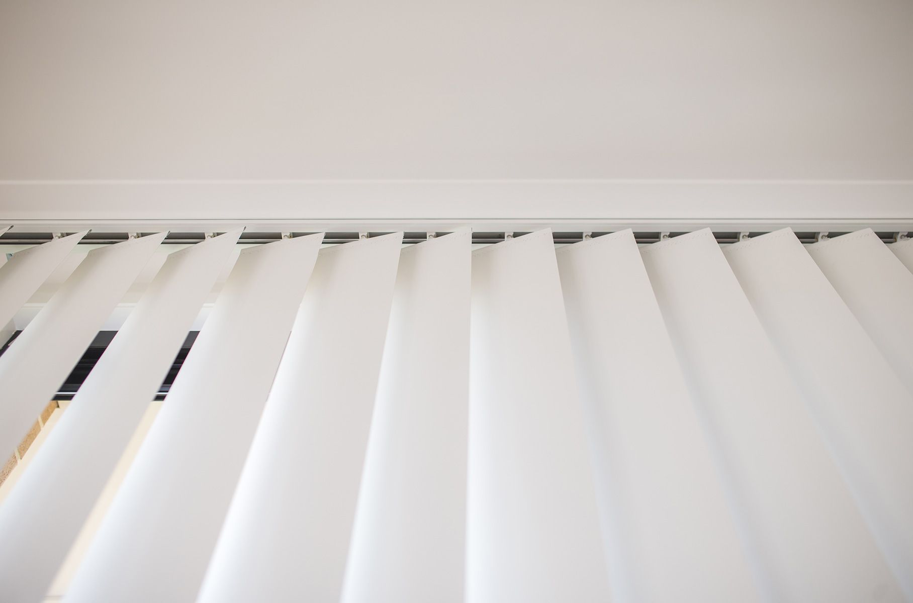 A Close Up Of A White Vertical Blind On A Window — Wares Blinds, Screens & Awnings In Gladstone Central, QLD