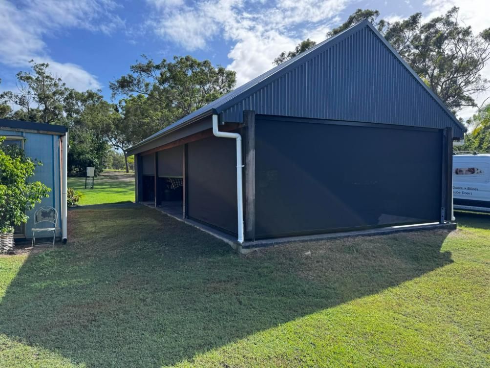 A Black Garage With A White Van Parked In Front Of It  — Wares Blinds, Screens & Awnings In Gladstone Central, QLD