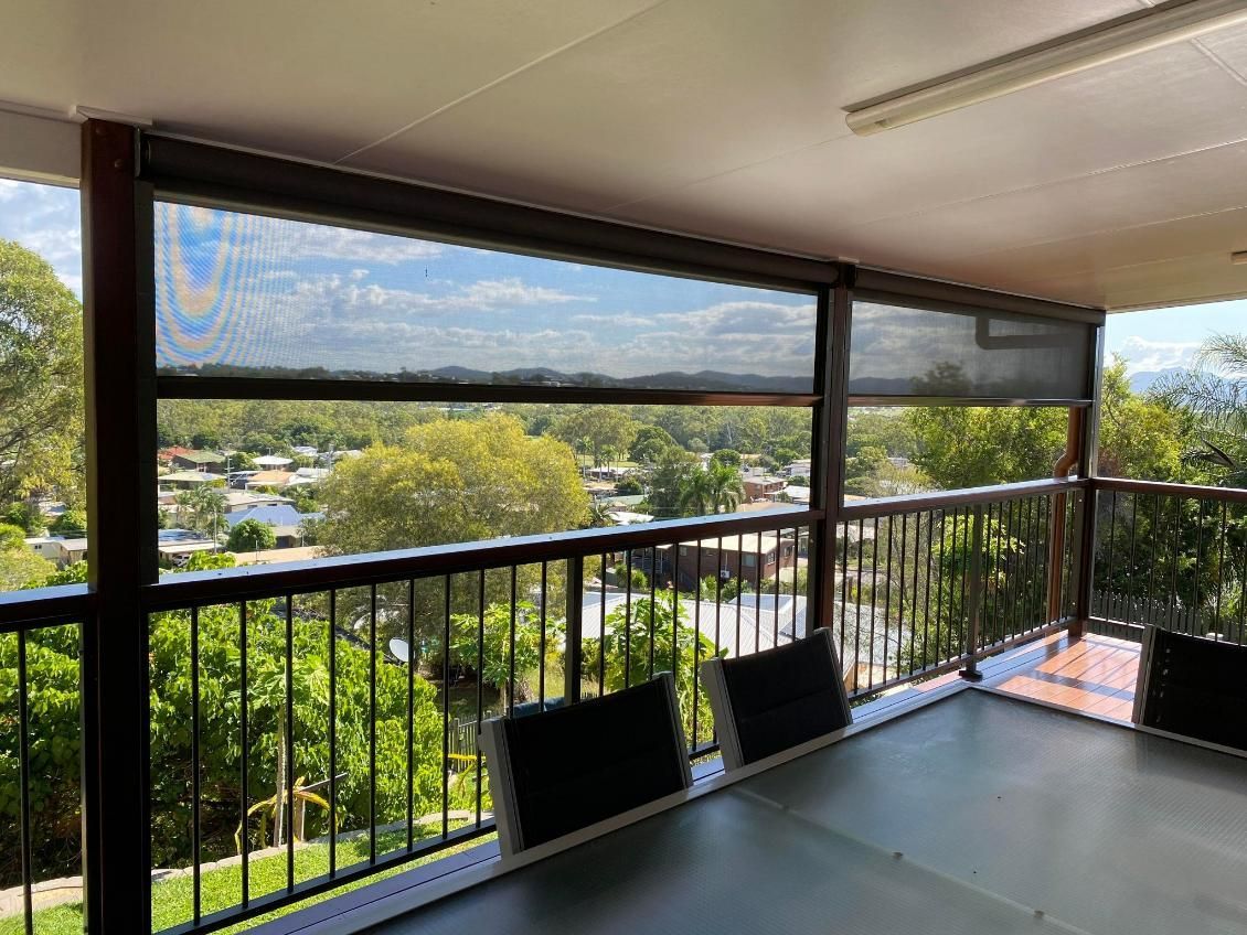 A Balcony With A Table And Chairs And A View Of A City  — Wares Blinds, Screens & Awnings In Gladstone Central, QLD