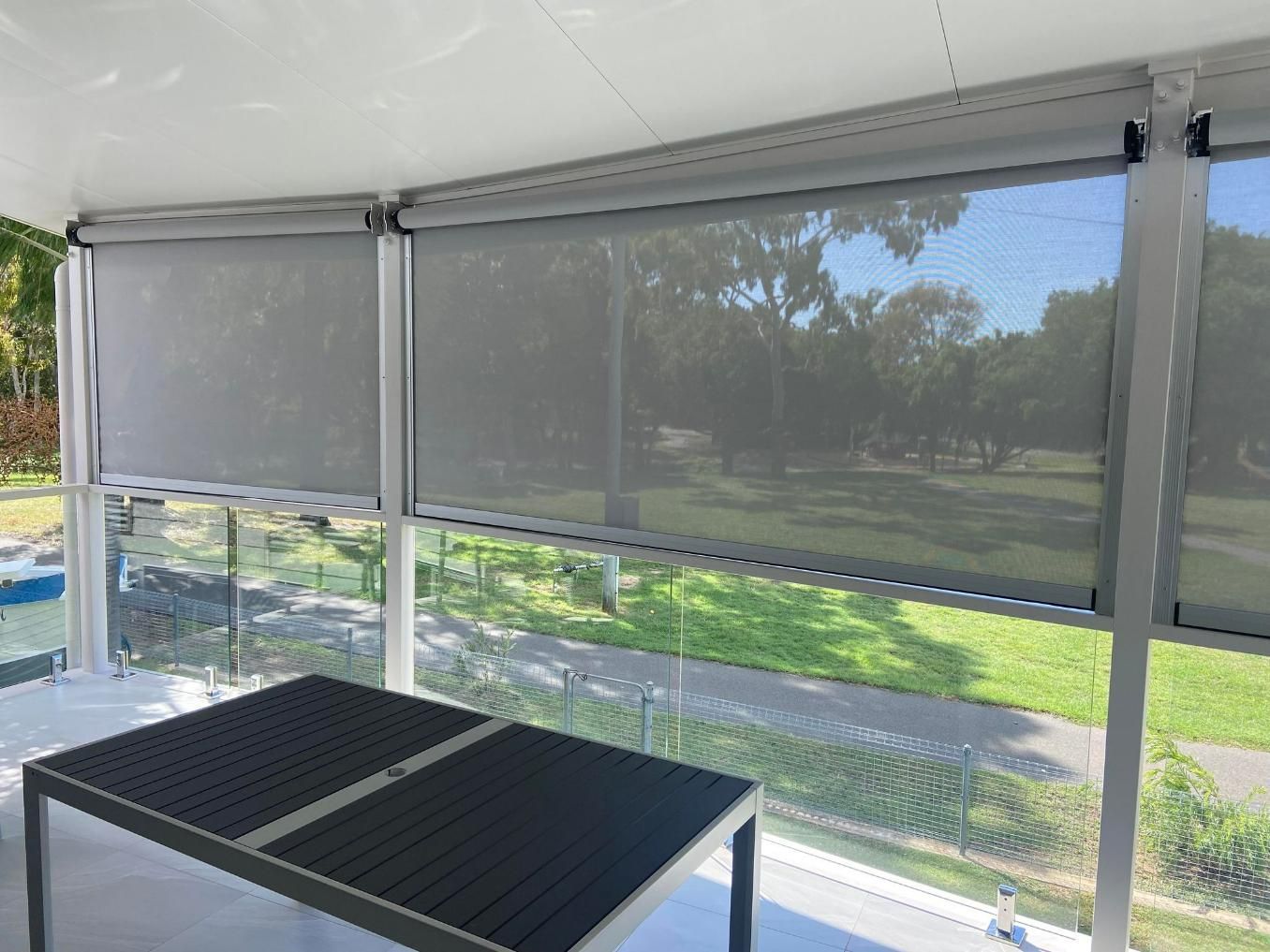 A Table Is Sitting On A Balcony With A View Of A Park — Wares Blinds, Screens & Awnings In Gladstone Central, QLD