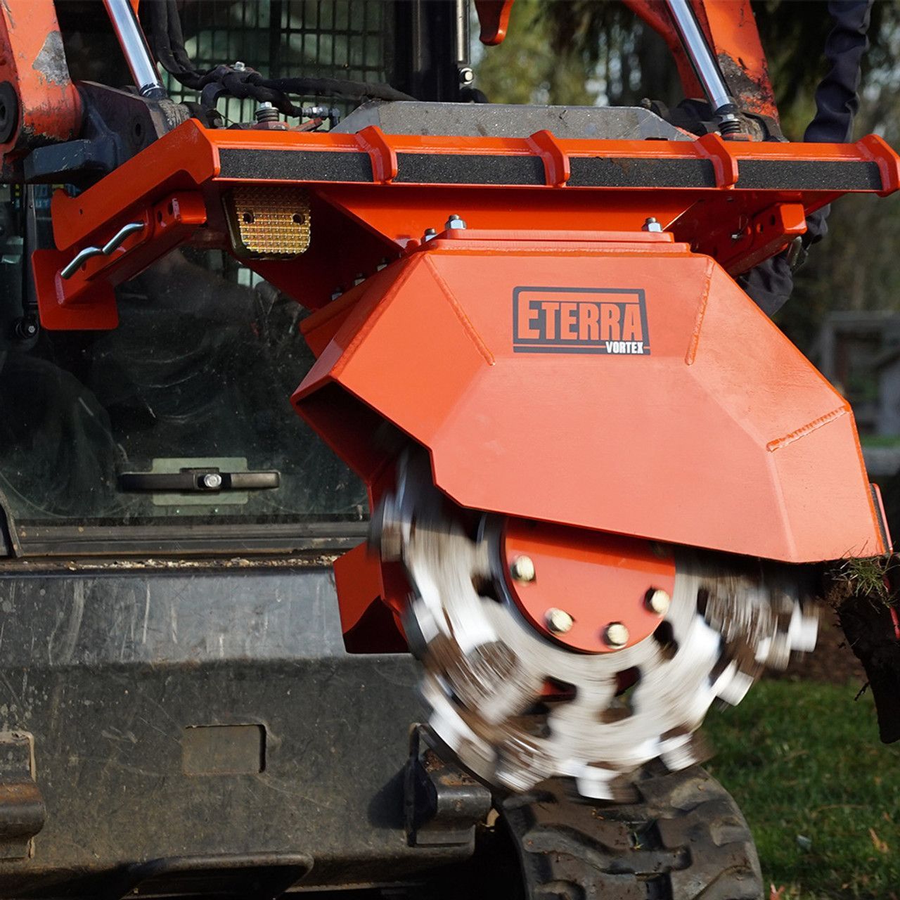 Eterra Vortex skid steer stump grinder attachment mounted on skid steer cutting tree stump during land clearing operation