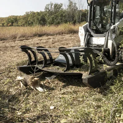 Prime Attachments direct drive skid steer brush mower actively cutting dense vegetation showing performance and blade speed