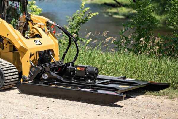 Brush Wolf open front skid steer brush cutter mowing brush along riverbank