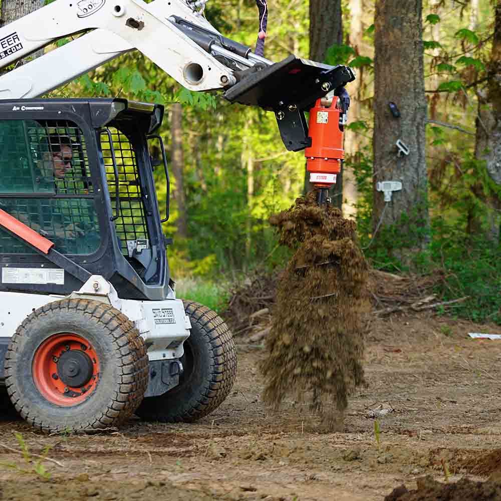 Skid steer auger drive attachment drilling post holes with Eterra auger motor