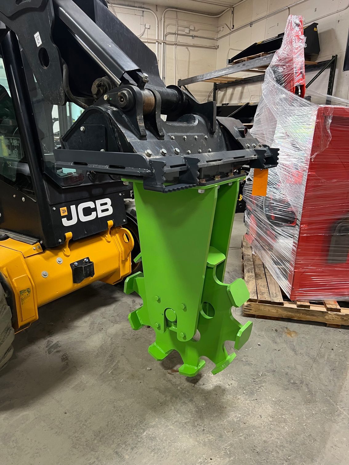 ECHO SSCW skid steer single compaction wheel attachment mounted on skid steer inside shop for trench soil compaction