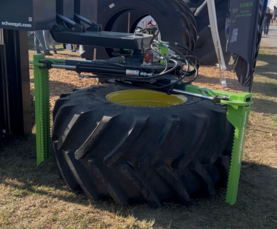 Skid steer tire handler positioning large sprayer tire showing controlled alignment and installation