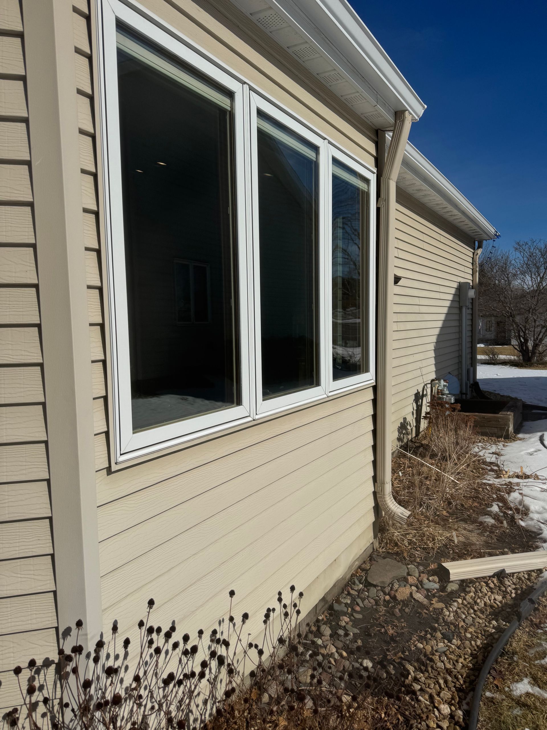 A house with three windows on the side of it