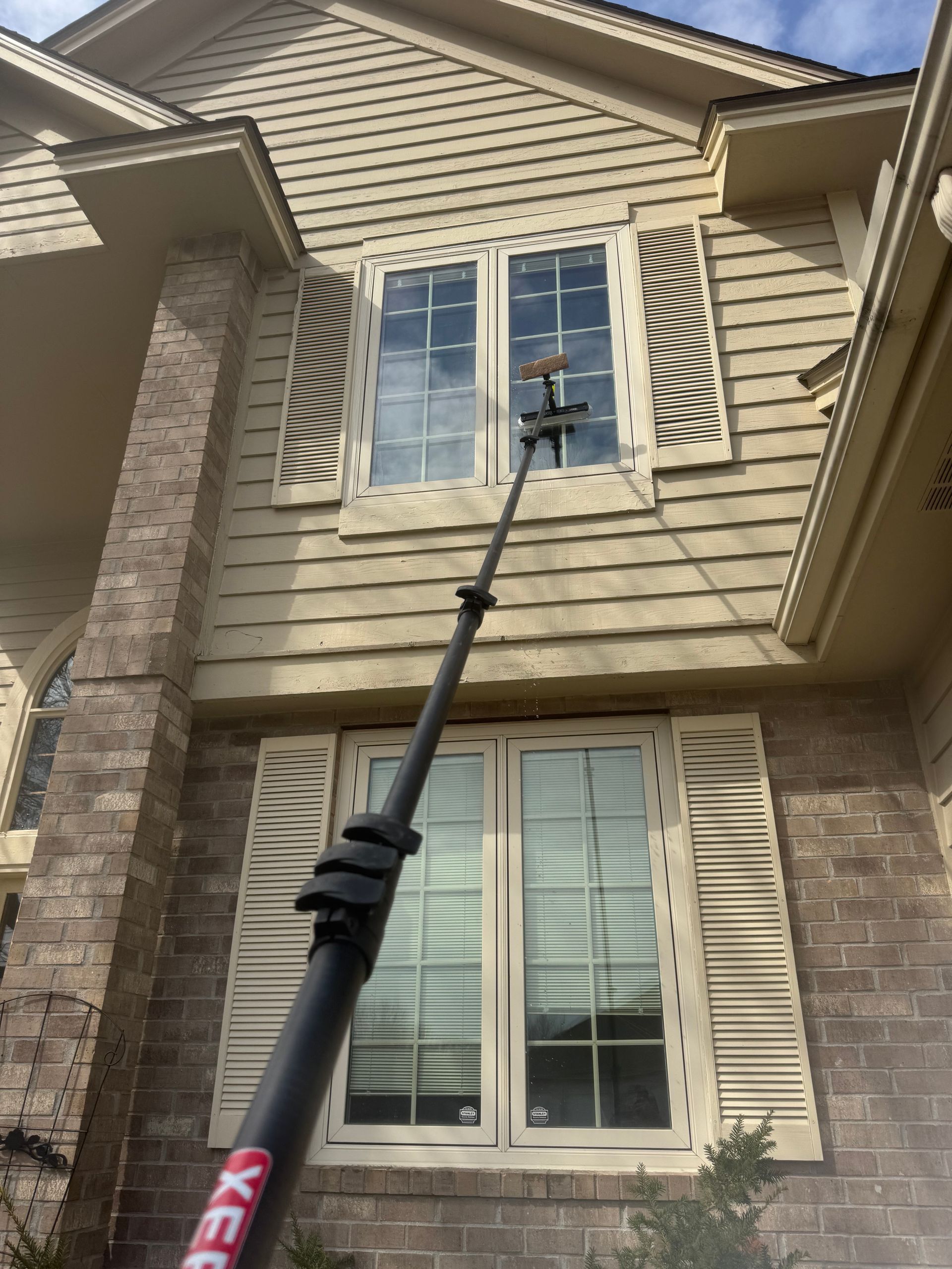 A person is cleaning the windows of a house with a machine.