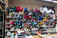 Shelves filled with various fabric rolls in a store; diverse colors and patterns.
