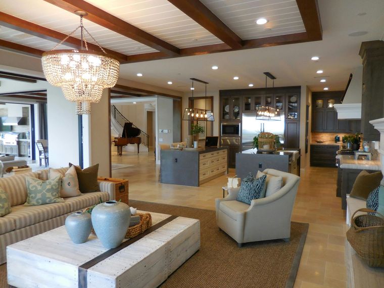 Open-concept living space with kitchen, seating area, and dining room; neutral tones, chandelier, and a piano.