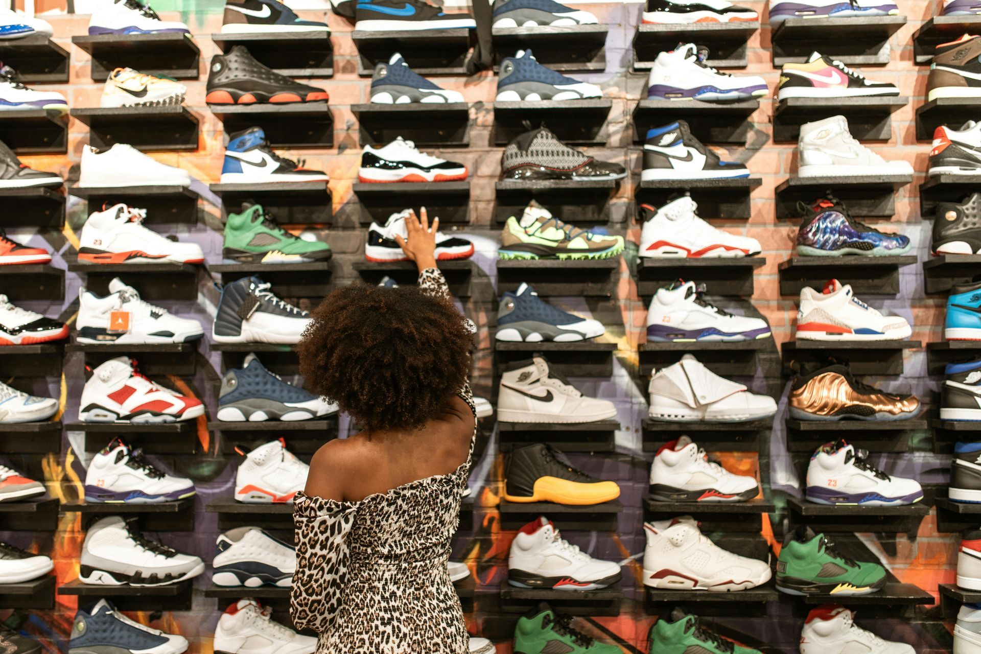 Woman shopping for sneakers on display in a store.