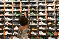 Woman shopping for sneakers on display in a store.