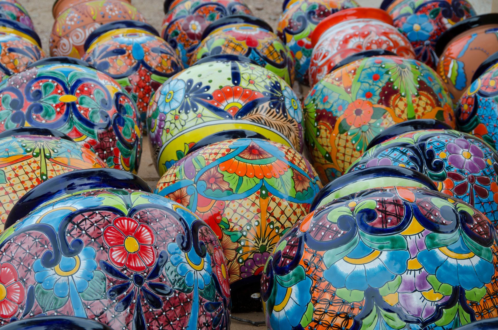 Colorful, intricately painted ceramic bowls with floral and geometric designs.