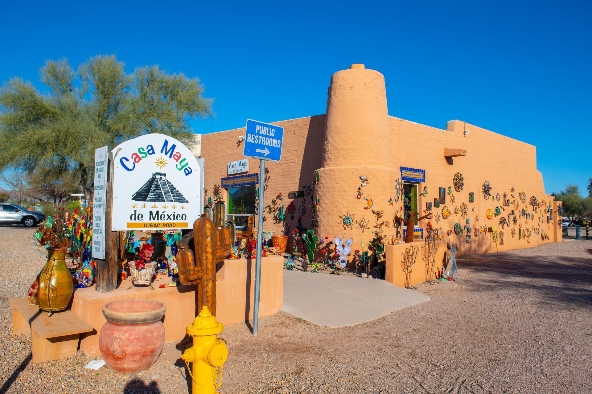 Casa Martin do México store, a peach-colored building with colorful pottery, cactus, and a sign under a blue sky.