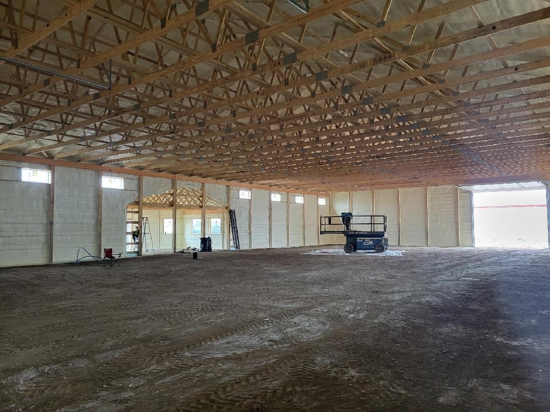 The inside of a large building under construction with a wooden roof.