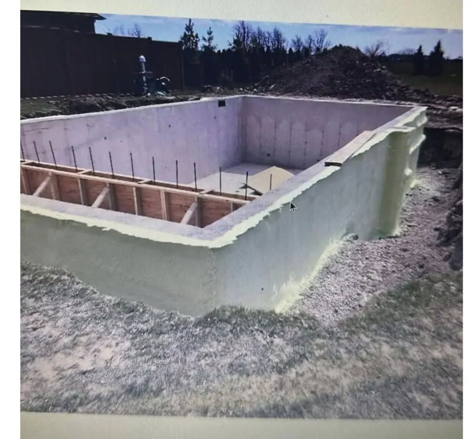 A large swimming pool is being built in the dirt