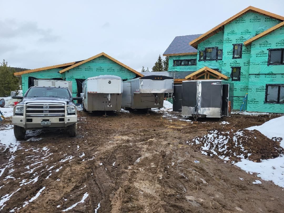 A truck is parked in front of a house under construction.