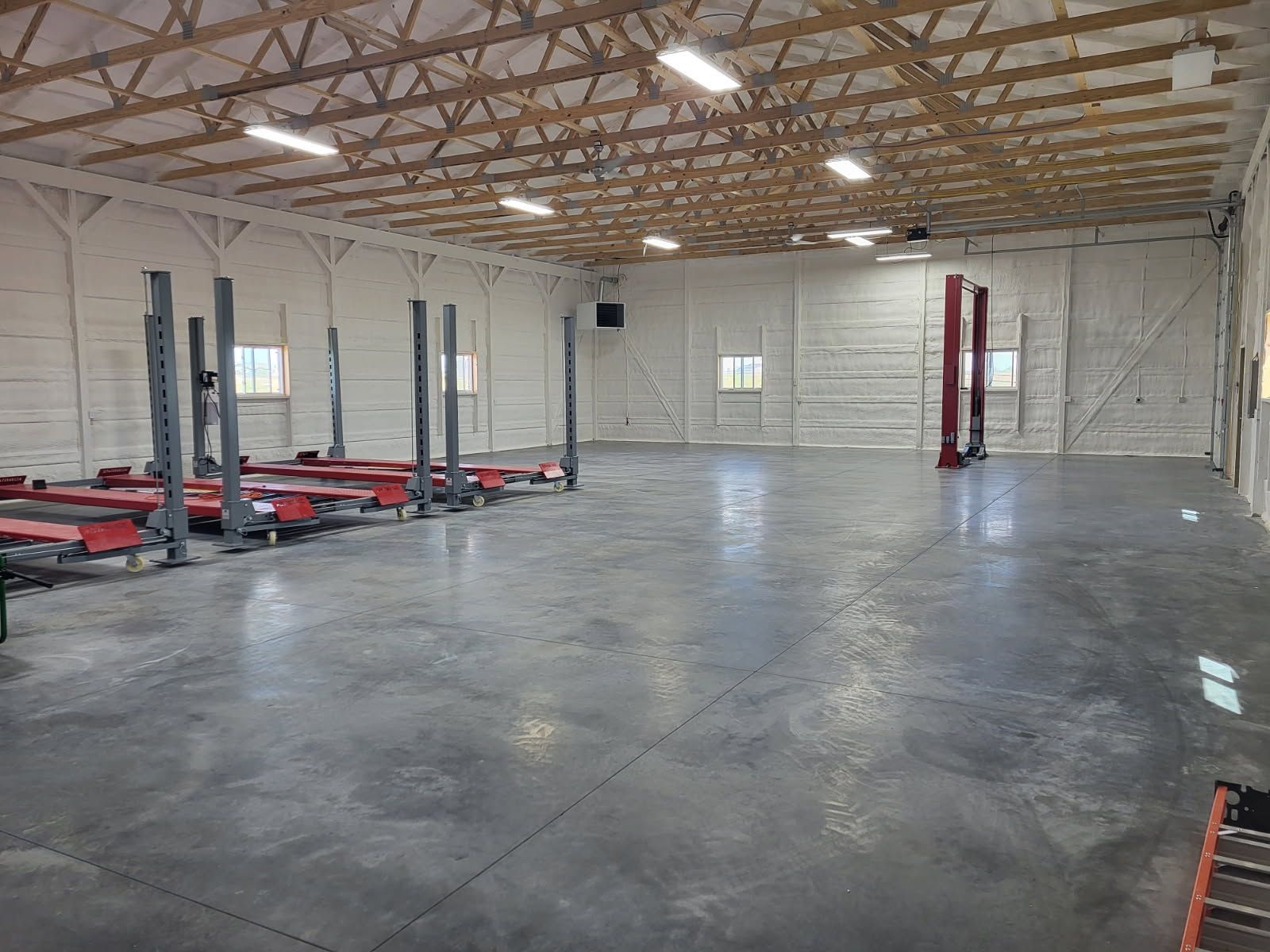 A large empty garage with a lot of lifts in it.